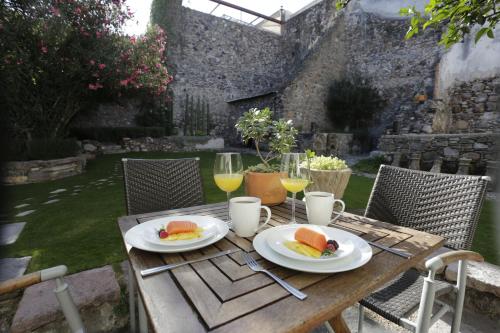 a wooden table with plates of food and glasses of wine at Orchid House San Miguel de Allende in San Miguel de Allende