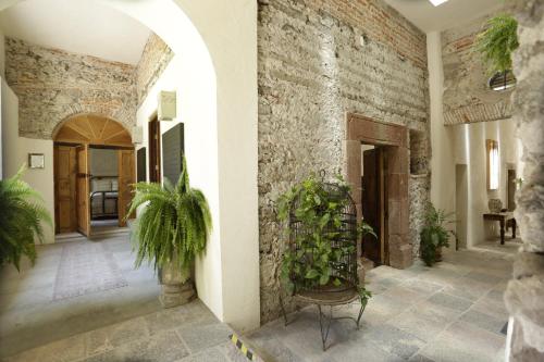 a hallway with a stone wall and plants at Orchid House San Miguel de Allende in San Miguel de Allende