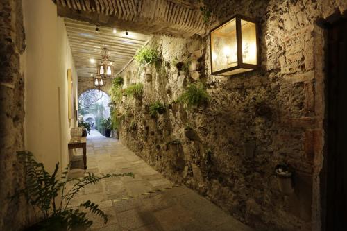 an alley in an old building with a light on the wall at Orchid House San Miguel de Allende in San Miguel de Allende