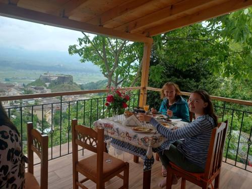 Dos mujeres sentadas en una mesa en un balcón en Guest House Hasko, en Gjirokastra