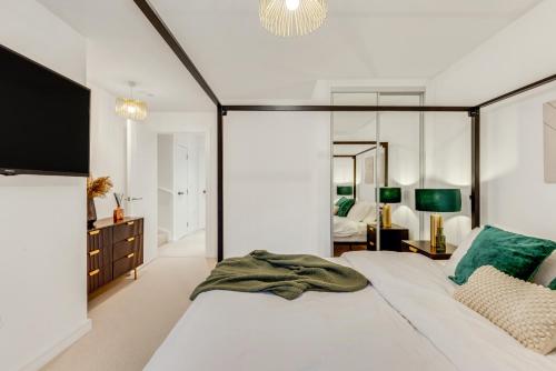 ein Schlafzimmer mit einem großen Bett und einem großen Spiegel in der Unterkunft Khayat Homes - The Emerald - Two Bed Luxury Apt in North Woolwich