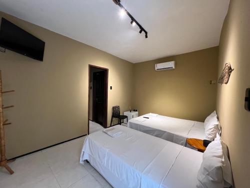 a hotel room with two beds and a television at VILA LITORANEA Hotel in São Luís