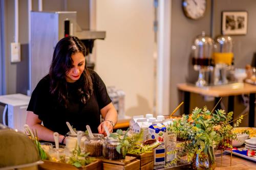 a woman sitting at a table looking at plants at Hotel Expo Stockholm in Stockholm