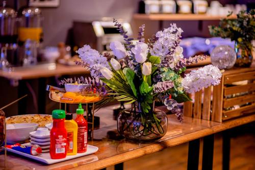 a table with a vase of purple flowers on it at Hotel Expo Stockholm in Stockholm