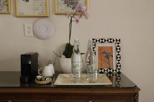 a table with two bottles and a vase on it at Orchid House San Miguel de Allende in San Miguel de Allende