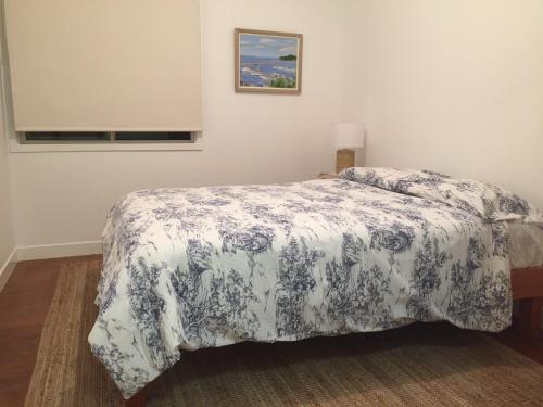 a bedroom with a bed with a blue and white bedspread at Creekside at Hat Head - 7 Creek Street in Hat Head