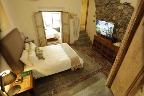 a hotel room with a bed and a television at Orchid House San Miguel de Allende in San Miguel de Allende