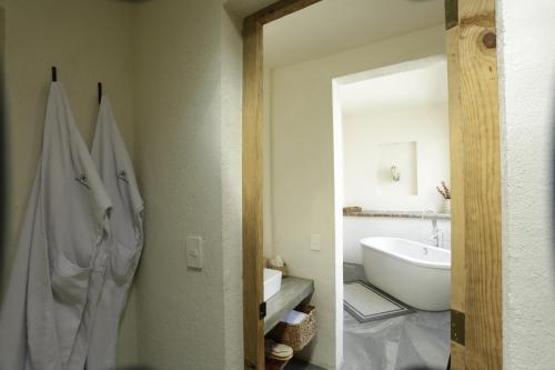 a bathroom with a white tub and a sink at Orchid House San Miguel de Allende in San Miguel de Allende