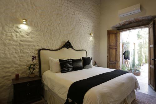 a bedroom with a bed with black and white pillows at Orchid House San Miguel de Allende in San Miguel de Allende