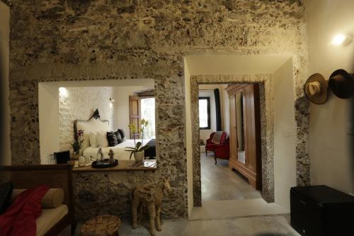 a living room with a stone wall with a mirror at Orchid House San Miguel de Allende in San Miguel de Allende
