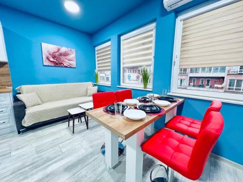 un salon avec des murs bleus et une table et des chaises rouges dans l'établissement NJ Deluxe rooms, à Varna