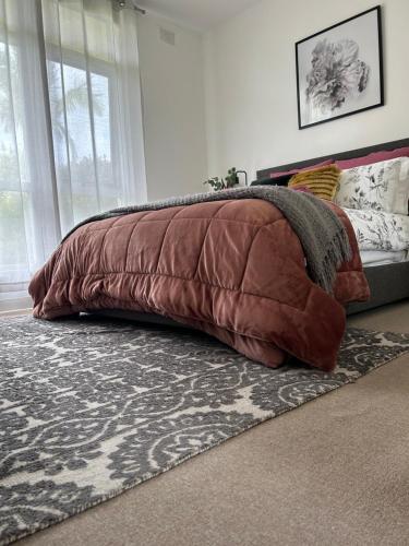 1 dormitorio con una gran almohada marrón sobre una alfombra en Sunshine Four, en Salisbury