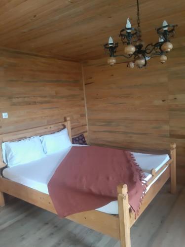 a bed in a room with wooden walls at ida bay doğa evleri in Edremit