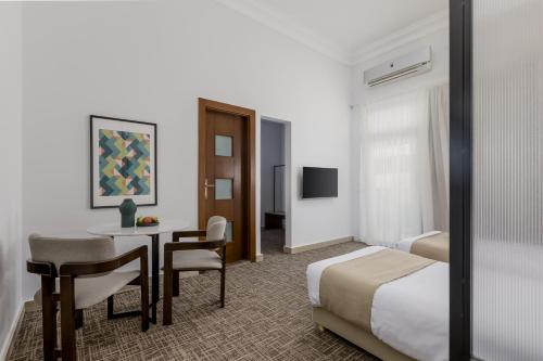 a hotel room with a bedroom with a bed and a desk at Livingville The Two-Fifty in Cairo