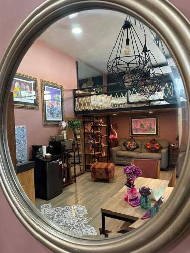 a mirror reflection of a living room with a table at “Encantador Loft” - en el corazón de San Pedro in Guadalajara
