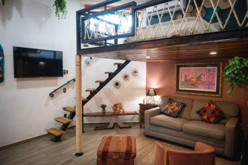 a living room with a staircase and a couch at “Encantador Loft” - en el corazón de San Pedro in Guadalajara