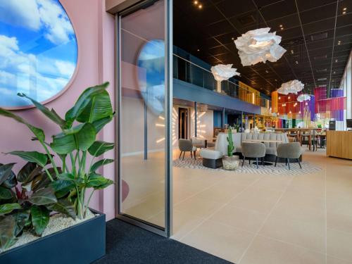 a lobby of a restaurant with a table and chairs at ibis Styles Rotterdam Ahoy in Rotterdam