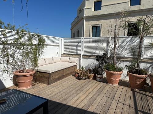 a patio with a couch on a wooden deck at Casa Guido Eco Friendly in Lecce