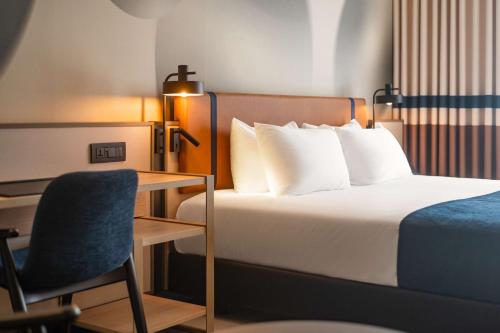 a bedroom with a bed and a desk and a chair at Best Western Premier Malta in St Paul's Bay
