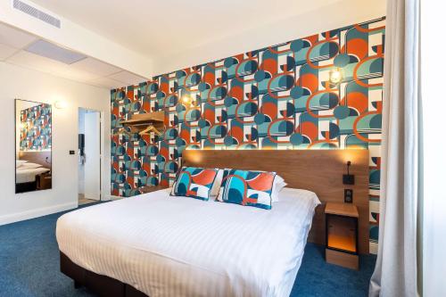 a bedroom with a bed and a colorful wall at Best Western Metz Centre Gare in Metz