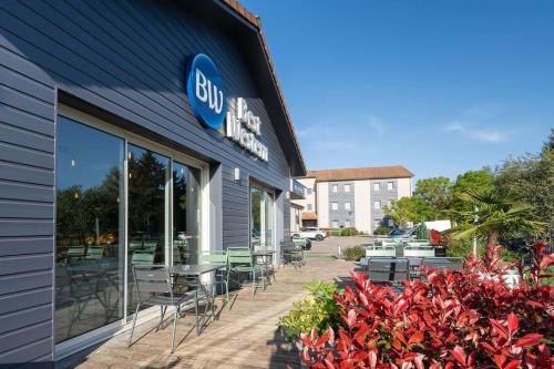 a building with chairs and tables outside of it at Best Western Bourgoin Jallieu in Bourgoin