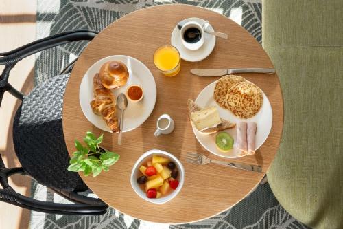 a table with two plates of food and a cup of coffee at Best Western Bourgoin Jallieu in Bourgoin