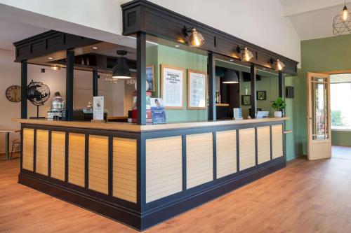 a restaurant with a counter in a room at Best Western Bourgoin Jallieu in Bourgoin