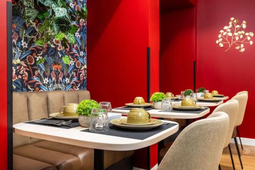 a dining room with two tables and chairs and red walls at Best Western Metz Centre Gare in Metz