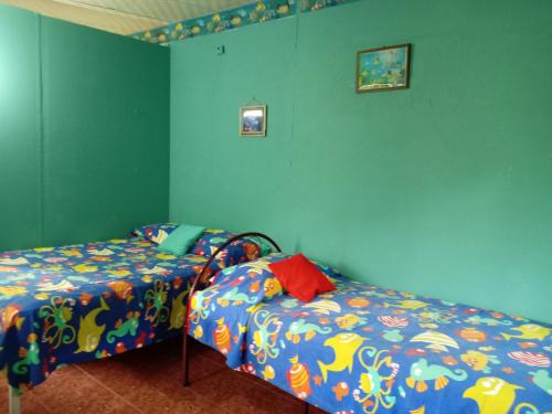 a bedroom with two beds and blue walls at Villa la paz in Valle de Anton