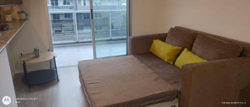 un sofá marrón con almohadas amarillas en la sala de estar. en Isabella 9 - Ciudad Cultural en San Salvador de Jujuy