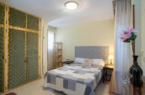 1 dormitorio con 1 cama con manta azul y blanca en Habitación doble con baño compartido en Benalmadena, en Benalmádena