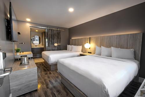 a hotel room with two beds and a television at Oasis at Gold Spike in Las Vegas