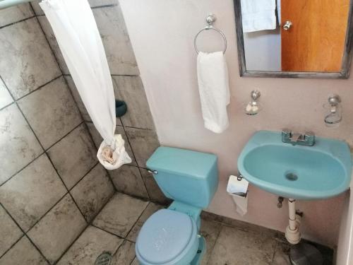 y baño con aseo azul y lavamanos. en casa agave, en San José del Cabo