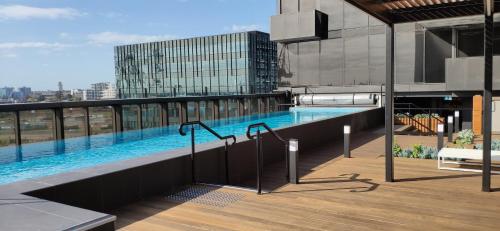 a swimming pool on the roof of a building at Centrally Located Modern Loft w Free Parking, Infinity Pool, Workspace in Melbourne