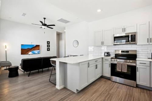 a kitchen with white cabinets and a stove top oven at Breezy Modern House in Casa Grande with Pool,BBQ in Casa Grande