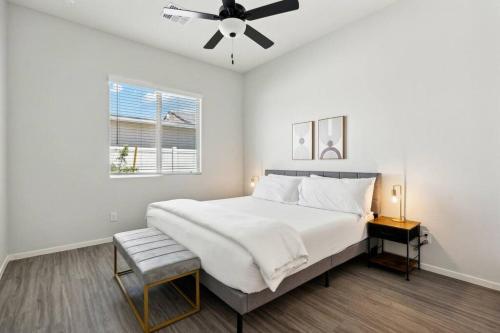 a white bedroom with a bed and a ceiling fan at Breezy Modern House in Casa Grande with Pool,BBQ in Casa Grande