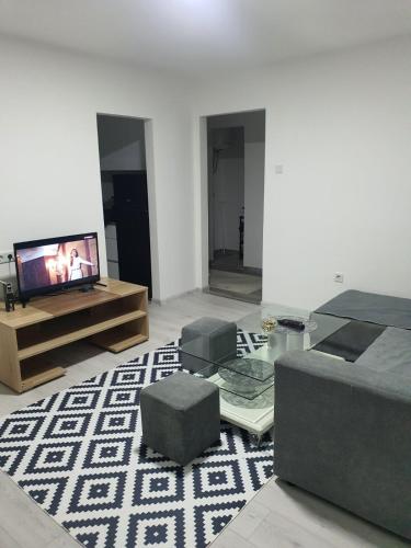 Una sala de estar con un televisor de pantalla plana y un sofá. en Ajša apartmani, en Sarajevo