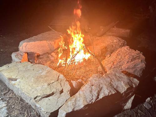 a fire pit with rocks and flames in it at 10 point landing Mammoth Cave Glamping Sublimity in Horse Cave