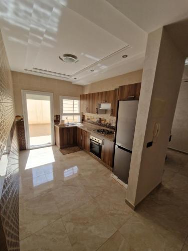 Il comprend une grande cuisine équipée d'un réfrigérateur et d'une cuisinière. dans l'établissement Appartement saidia 3 chambre à 150 m de la plage, à Saïdia