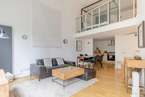 a living room with a couch and a table at Chic 1BD Maisonette wHot Tub King's Cross! in London