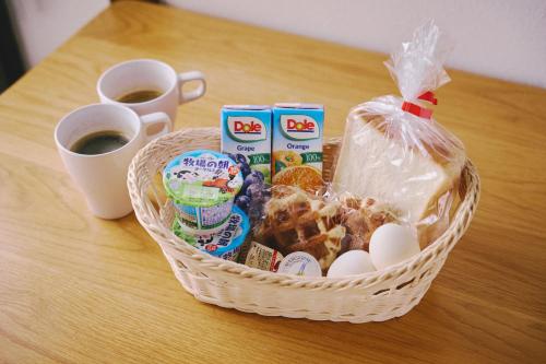 a basket of breakfast food and coffee on a table at Guest Living Mu Nanki Shirahama in Shirahama