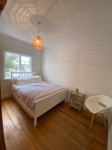 1 dormitorio con 1 cama, 1 mesa y 1 lámpara en Driftwood Sorrento beach house, en Sorrento