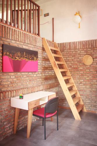 a wooden staircase in a room with a desk and a chair at Cielo de Tierra in Coronel Suárez