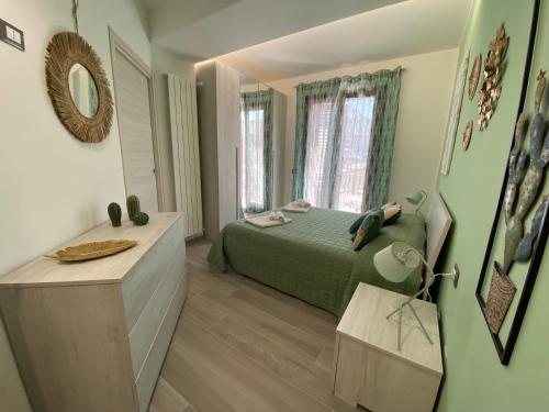 um quarto com uma cama verde e um espelho em La Terrazza del Capo em San Vito lo Capo