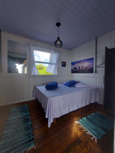 Schlafzimmer mit einem großen Bett und einem Fenster in der Unterkunft Pousada Kahuna Farol in Laguna