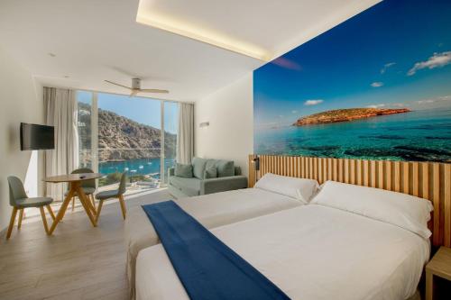a bedroom with a bed and a view of the ocean at Hotel El Pinar in Cala Llonga