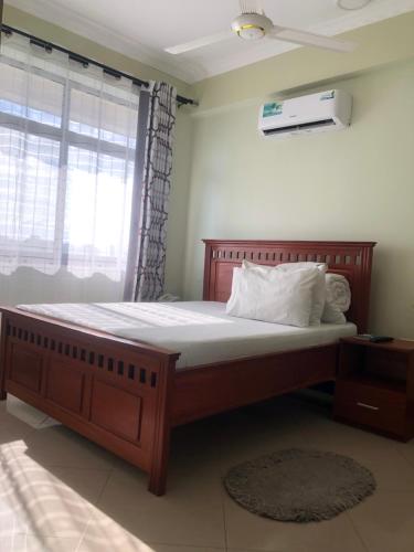 ein großes Bett in einem Zimmer mit Fenster in der Unterkunft Mbazi Hotel in Tanga
