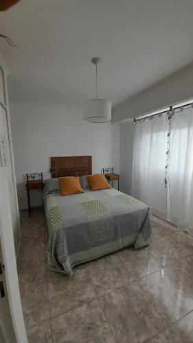 um quarto com uma cama num quarto branco em departamento tandil em Tandil