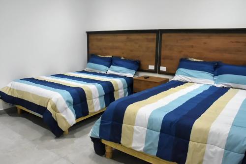 a bedroom with two beds with blue and white sheets at Marazul-Home in Playa del Carmen