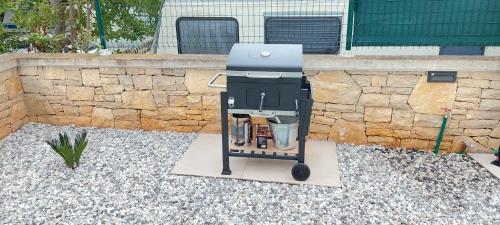 - un barbecue installé devant un mur en pierre dans l'établissement Apartment Luna Banjole, à Banjole